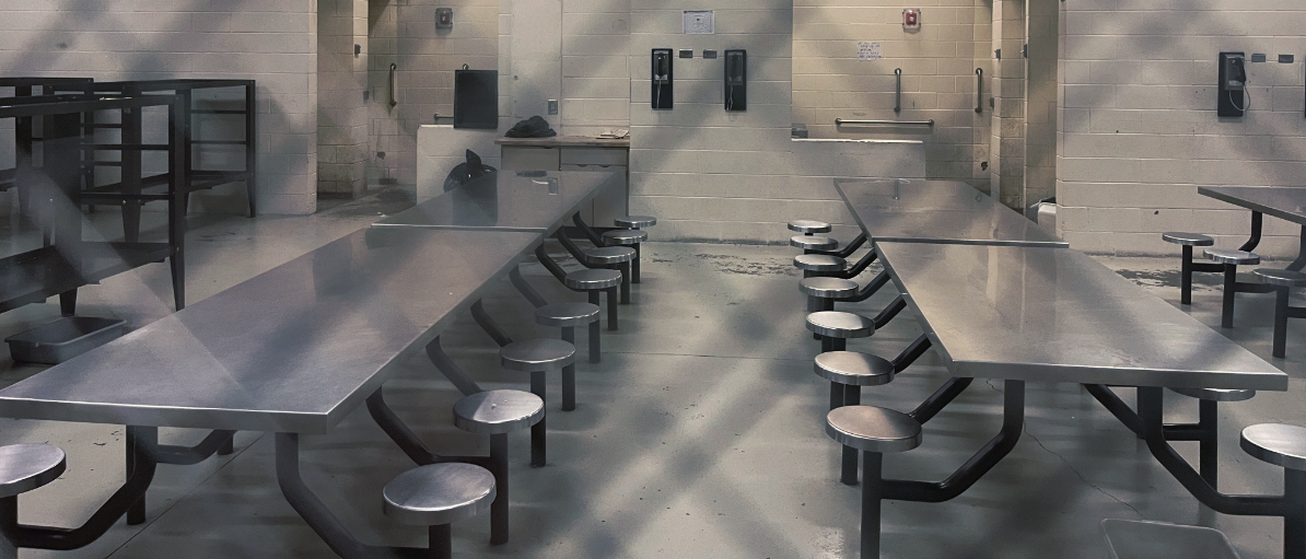 jail room with gray table and stools